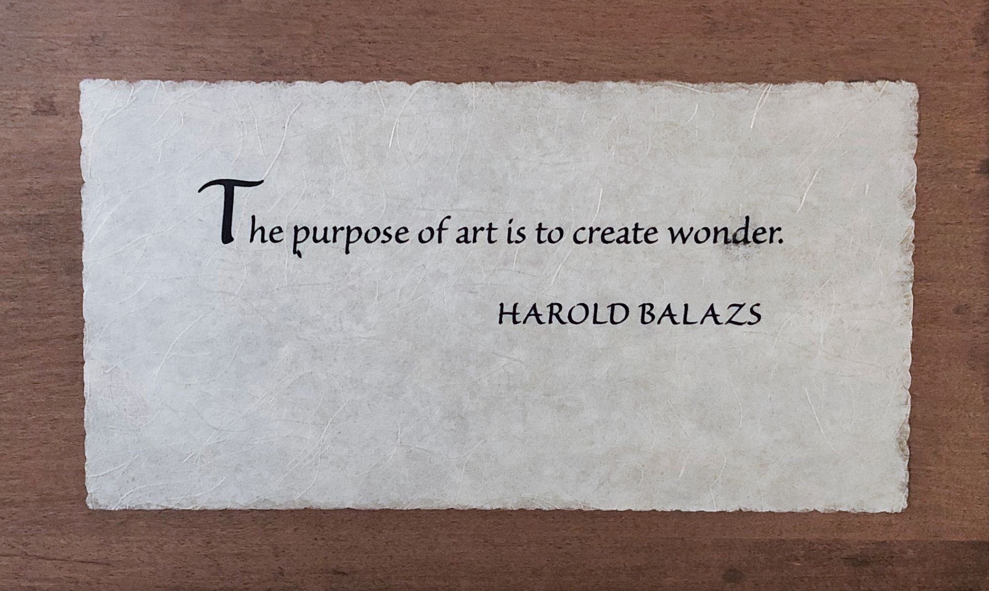 Photo of wooden plaque with Harold Balazs quote: “The purpose of art is to create wonder.”