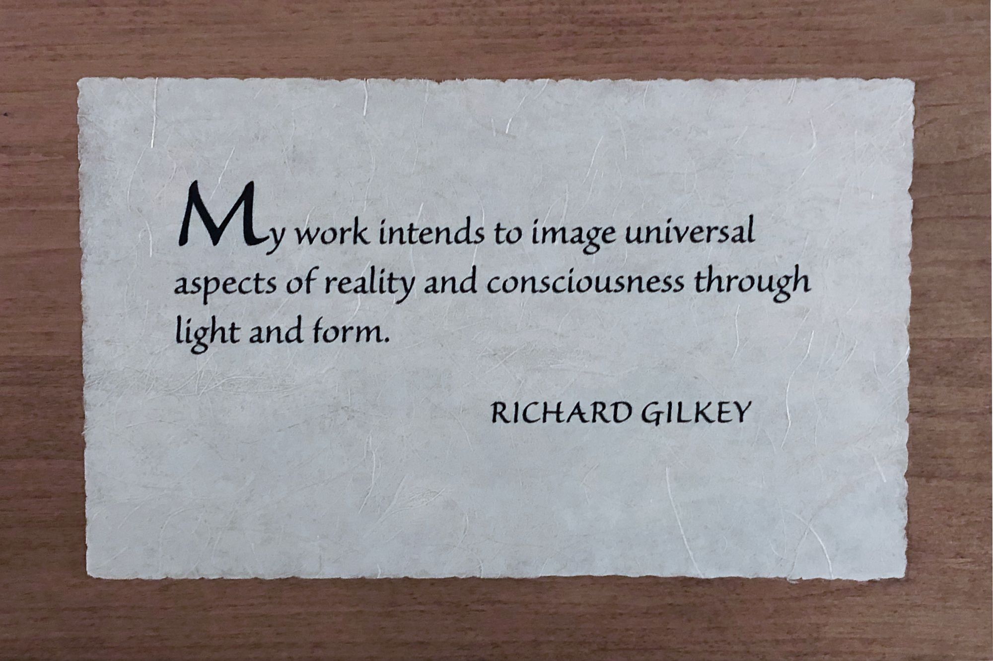 Photo of wooden plaque with Richard Gilkey quote: “My work intends to image universal aspects of reality and consciousness through light and form.”