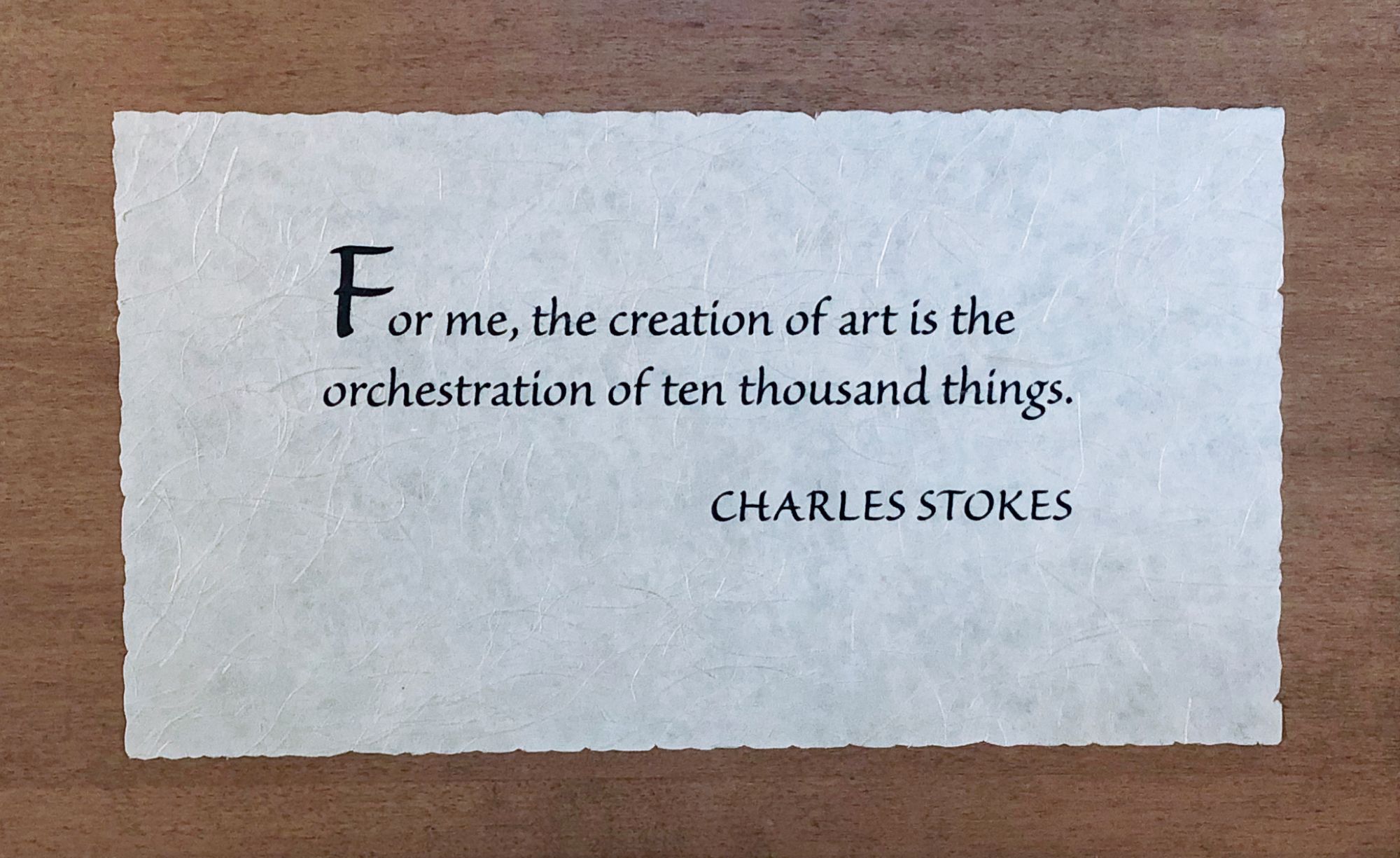 Photo of wooden plaque with Charles Stokes quote: “For me, the creation of art is the orchestration of ten thousand things.” 