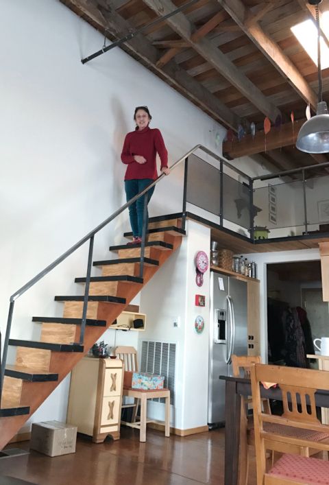 Sandra standing on the stairs in her Tieton Art Loft, December 2016, by  David Bilides
