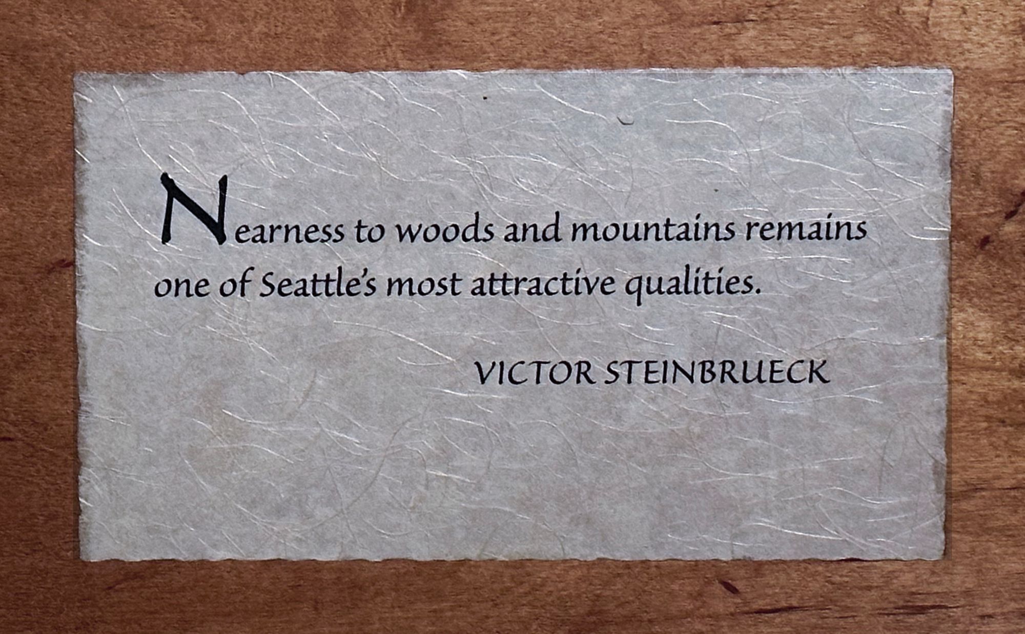 Photo of wooden plaque with Victor Steinbrueck quote: “Nearness to woods and mountains remains one of Seattle’s most attractive qualities.”
