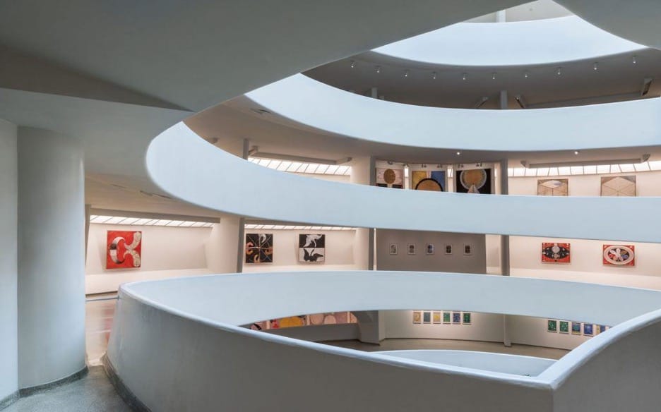 Two levels of spiral exhibition walkways at the Guggenheim Museum, showing art at each level.