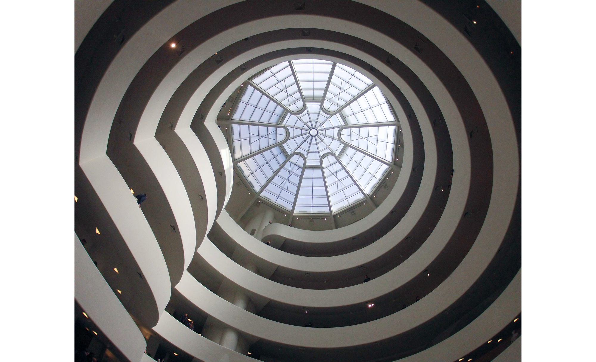 Photo of white spiral ramps leading to patterned skylight in middle of picture.