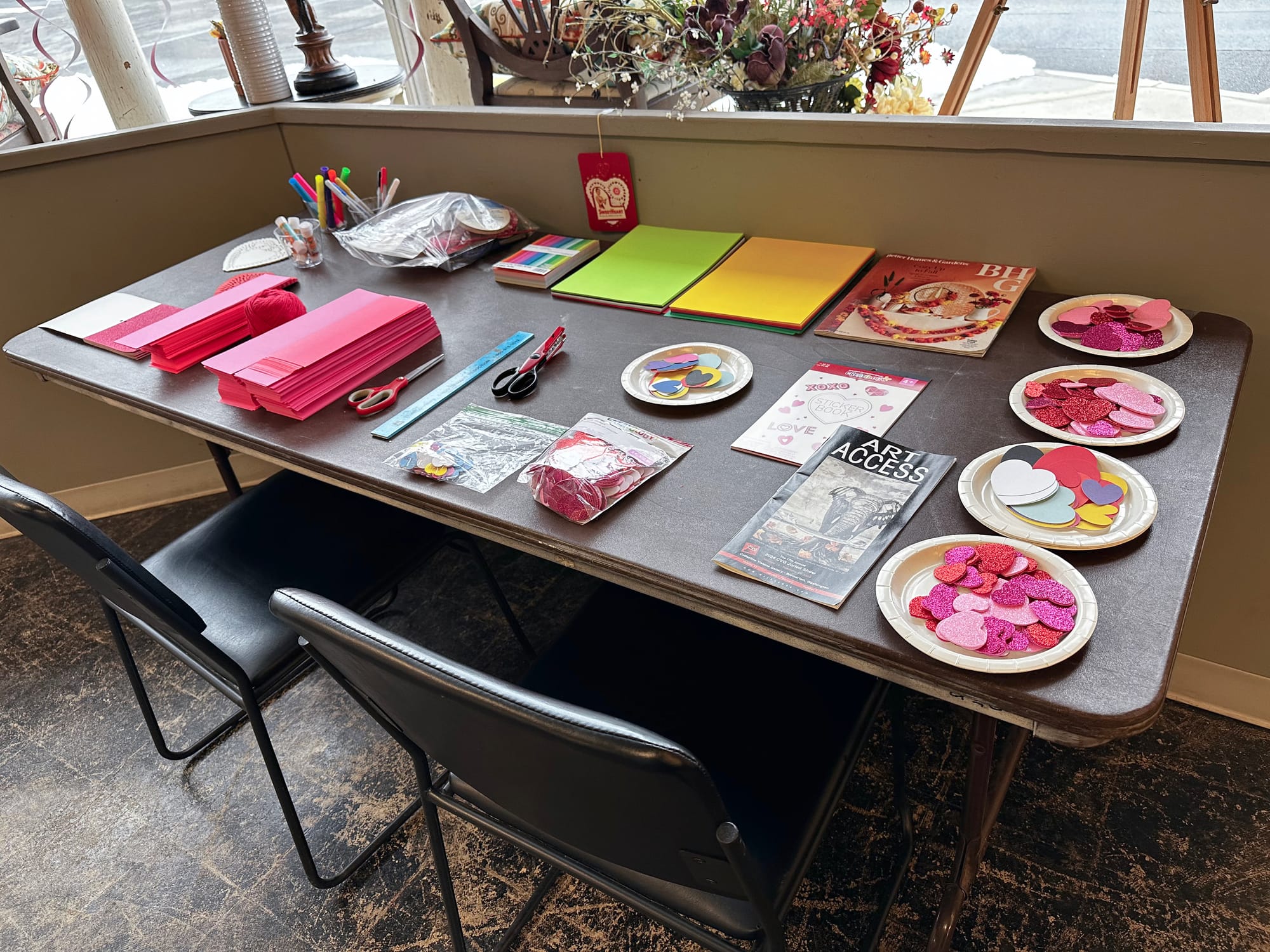 A table with brightly colored materials for making valentines