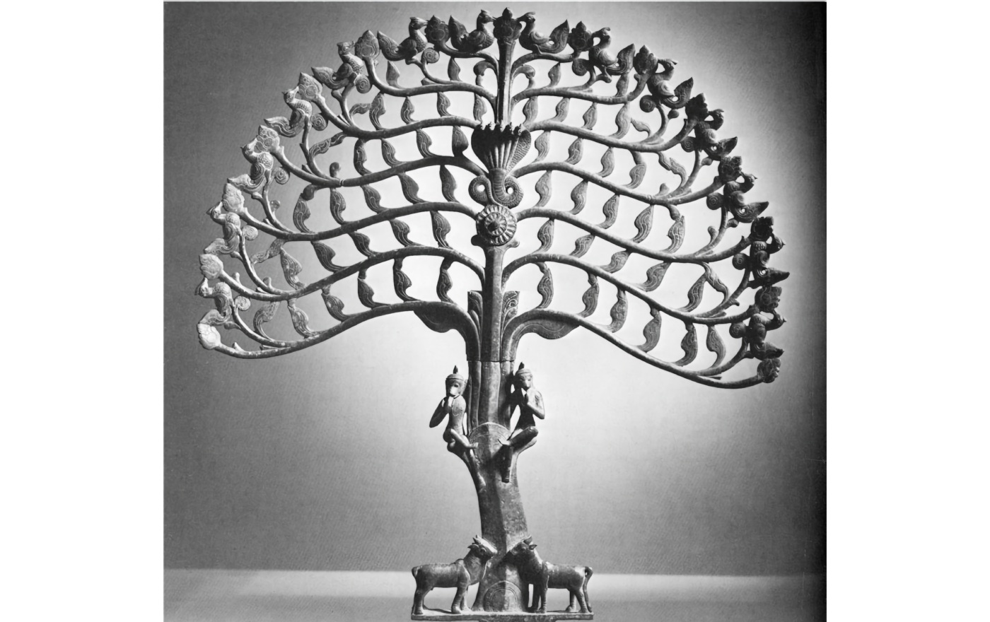 Photo of tree sculpture with many leaves and animals at base