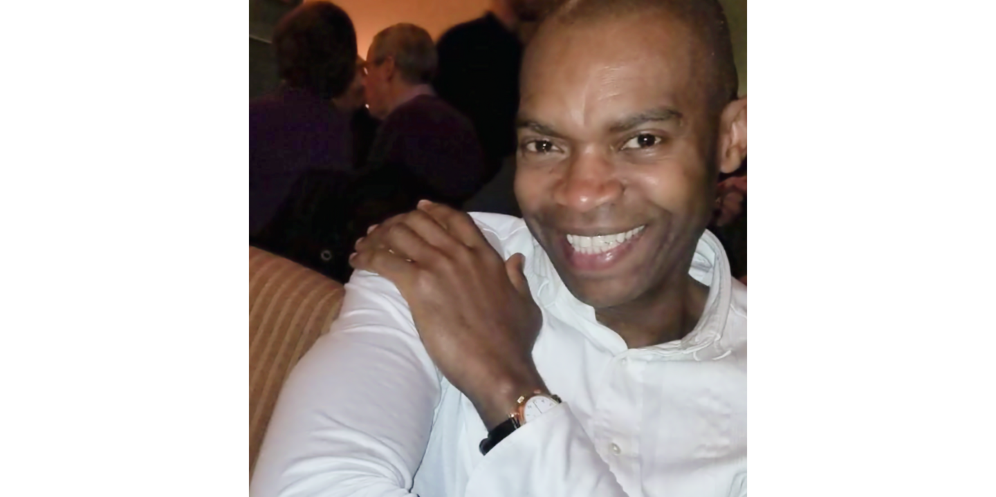 Photo of Yves Deshommes in white shirt, smiling.