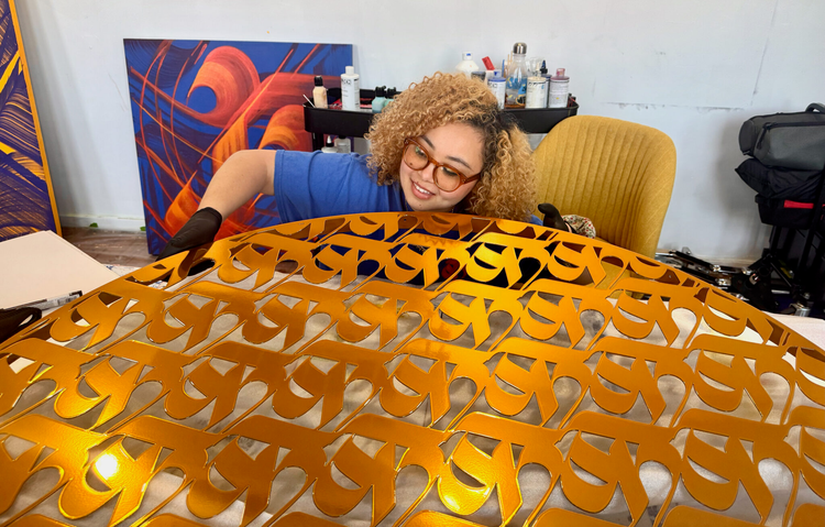 Photo of woman holding golden filigreed sculpture